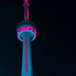 The CN tower with Toronto Raptor colors to highlight the question is hiring Bobby Webster the right decision.